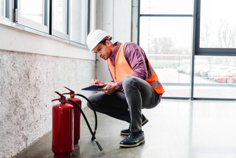 handsome fireman in helmet sitting near extinguish JUNAUVY.jpg
